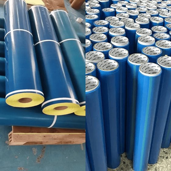 Rolls of blue industrial fabric or material stacked upright.